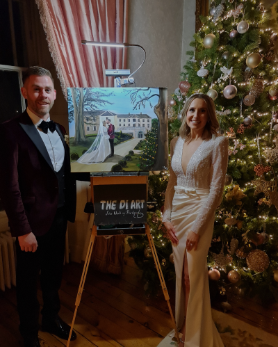 Happy couple in awe of their painting created by wedding painter Diana Merfeldiene