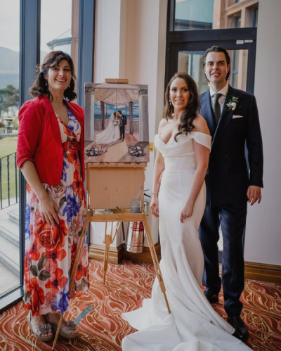 Live wedding painter Diana Merfeldiene, joined by the joyful couple, captures the magic of their special day in Ireland