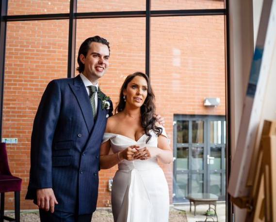 happy couple enjoying their live wedding painting created by Diana Merfeldiene