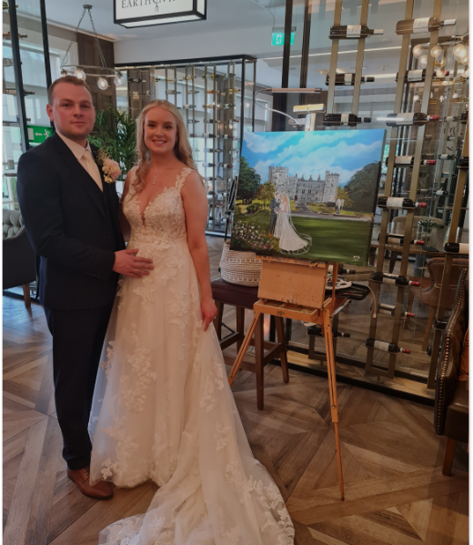 Happy couple awed by the beautiful painting created by live wedding painter Diana Merfeldiene